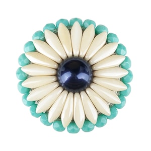 以下が含まれることがあります： ターコイズビーズで囲まれた、青い中心を持つ白い花のブローチです。