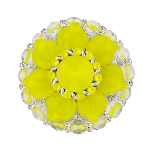 Könnte beinhalten: Eine gelbe Brosche in Blütenform mit einem klaren Kristall in der Mitte und einem silbernen Metallrahmen.