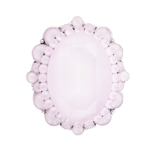 Op de afbeelding: Een roze ovale ring met een zilveren zetting en een decoratieve rand van kleine roze kralen.