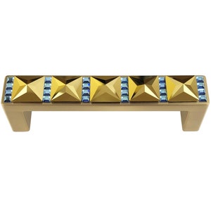 Può includere: Maniglia per armadio dorata con una fila di accenti di cristallo blu.