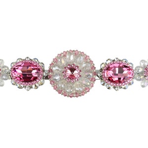 May include: A silver hair clip with pink and clear crystal embellishments in a floral design.