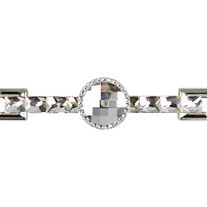 Könnte beinhalten: Ein silberner Schrankgriff mit einem Kristallzentrum und Kristallverzierungen. Der Griff ist rechteckig mit abgerundeten Kanten.