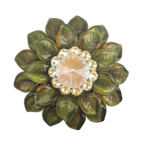 May include: A green glass flower brooch with a clear crystal centre.
