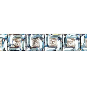 Puede incluir: Un broche de barra de cristal azul y transparente con un diseño geométrico. El broche tiene una fila de cristales cuadrados con cristales más pequeños que los rodean.
