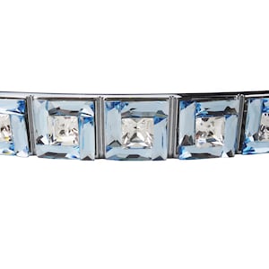 Op de afbeelding: Een zilveren ladegreep met vijf heldere blauwe kristallen accenten.