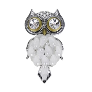 以下が含まれることがあります： シルバーカラーのフクロウのブローチ。透明なクリスタルの目、金色の目の周り、白い涙型のビーズと小さな真珠で飾られた体があります。 フクロウの頭には、小さくて丸い透明なクリスタルが付いています。