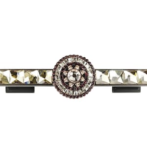 Könnte beinhalten: Ein dekorativer Schubladenzug mit Kristall- und Strassstein-Design. Der Zug ist silberfarben mit schwarzer Basis und verfügt über einen runden, mehrfarbigen Kristall-Schmuck.