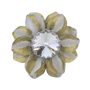 May include: A gold and white flower-shaped embellishment with a clear crystal in the center.