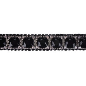 Op de afbeelding: Een zwarte haarspeld met een rij grote, zwarte, vierkante strassstenen omgeven door kleinere, heldere strassstenen.