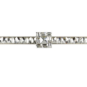 Peut inclure: Une barre argentée avec un motif de cristal transparent. La barre a un grand cristal carré au centre.