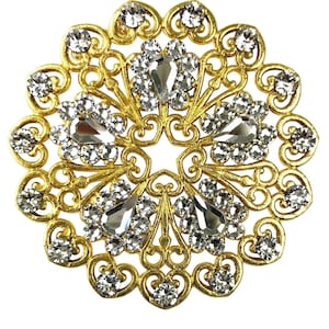 May include: A gold-toned metal brooch with a circular design featuring a filigree pattern and clear rhinestones.