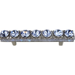 Op de afbeelding: Een zilveren ladegreep met een rij lichtblauwe kristallen strass.