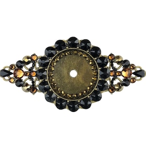 以下が含まれることがあります： 黒と琥珀色のクリスタルで飾られた丸い金属製の装飾品。装飾品の中央には穴があり、黒色のクリスタルの輪で囲まれています。