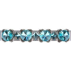 Puede incluir: Pulsera de metal plateado con cuatro grandes adornos redondos en forma de flor de cristal azul claro. Cristales más pequeños en forma de diamante y detalles de metal plateado se intercalan entre las flores. Fondo blanco.