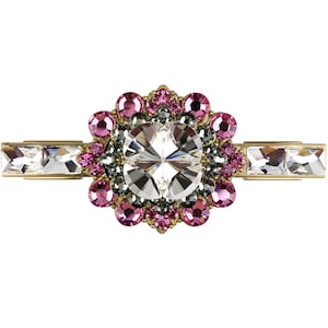 Könnte beinhalten: Eine goldfarbene Haarklammer mit einem großen, klaren Kristall, umgeben von kleineren rosa und grauen Kristallen.