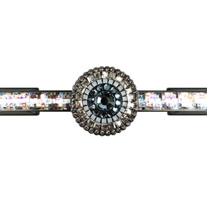 May include: A black metal drawer pull with a round crystal knob. The knob is surrounded by smaller crystals in a circular pattern.