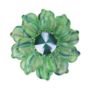 以下が含まれることがあります： 中央に大きなファセットカットの濃い緑色の宝石が、周囲に小さな緑色の宝石で囲まれた緑色のガラスの花のブローチです。