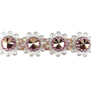 Op de afbeelding: Een gouden balk met vier heldere kristallen bloemversieringen. Elke bloem heeft een roze centrum met een gouden strasssteen.