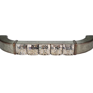 Könnte beinhalten: Ein silberner und grüner Metall-Schrankgriff mit einem dekorativen Mosaikdesign. Der Griff hat eine gebogene Form und ist für die Verwendung an Schränken und Schubladen konzipiert.