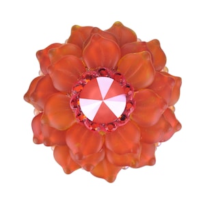 May include: A red and orange glass flower with a large red rhinestone in the center.