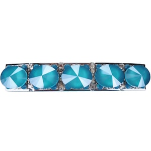 Puede incluir: Una pinza para el pelo plateada con cinco piedras de cristal azul turquesa.