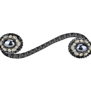 Könnte beinhalten: Schwarzer Metall-Schubladengriff mit zwei ovalen Kristallknöpfen. Jeder Knopf hat einen schwarzen Edelstein, der von kleineren klaren und schwarzen Kristallen umgeben ist.