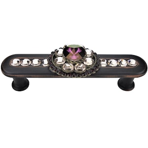 Może przedstawiać: Brązowy uchwyt do szafki z ozdobą z kryształów i fioletowych cyrkonii.