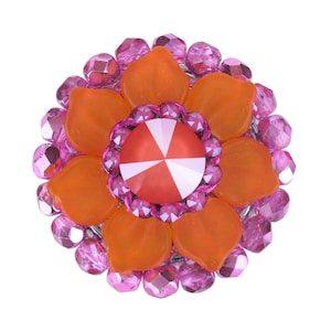 Könnte beinhalten: Eine rosa und orangefarbene Brosche in Blumenform mit einem roten und weißen Zentrum. Die Brosche besteht aus Perlen und hat eine glänzende Oberfläche.