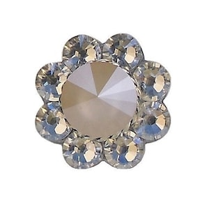May include: A clear crystal flower-shaped embellishment with a central, round, opaque, light pink crystal.
