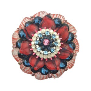 Peut inclure: Une broche circulaire composée de couches de pétales rouges translucides, de cristaux facettés bleu foncé et d'un groupe central de pierres bleu clair entouré d'un anneau de petites perles blanches avec un cristal rose au centre.