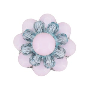 May include: A pink flower-shaped button with a light blue crystal center.