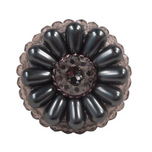 Peut inclure: Une broche en forme de fleur de couleur gris foncé avec un grand cristal noir facetté au centre. La broche est faite de petites perles rondes et a un design délicat et féminin.