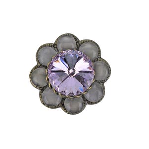 Peut inclure: Un bouton en forme de fleur avec un strass violet et un cadre en métal argenté.