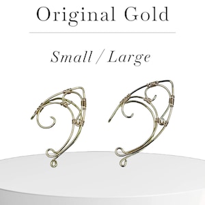 May include: Two gold wire ear cuffs, one small and one large, with intricate designs. Original Gold, Small/Large.