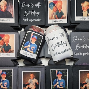 Personalized photo birthday can coolers for a 40th birthday party, featuring childhood pictures with ‘Vintage 1986’ text and custom designs reading ‘Drew’s 40th Birthday Aged to Perfection.’ Custom party drink holders displayed on a rustic wood background.