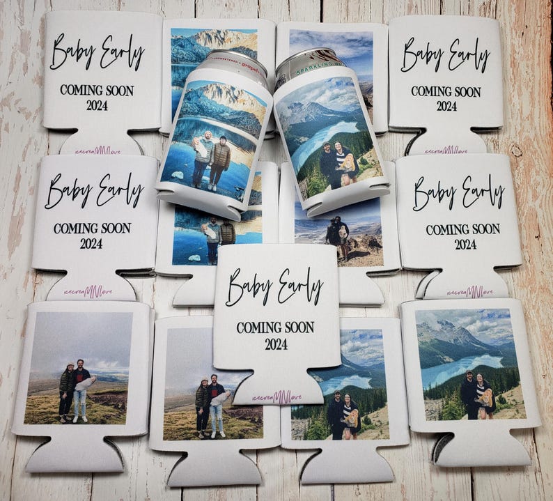 May include: White can coolers with the text "Baby Early COMING SOON 2024" in black script. Some coolers hold cans with scenic photos. The coolers are designed to keep beverages cold.