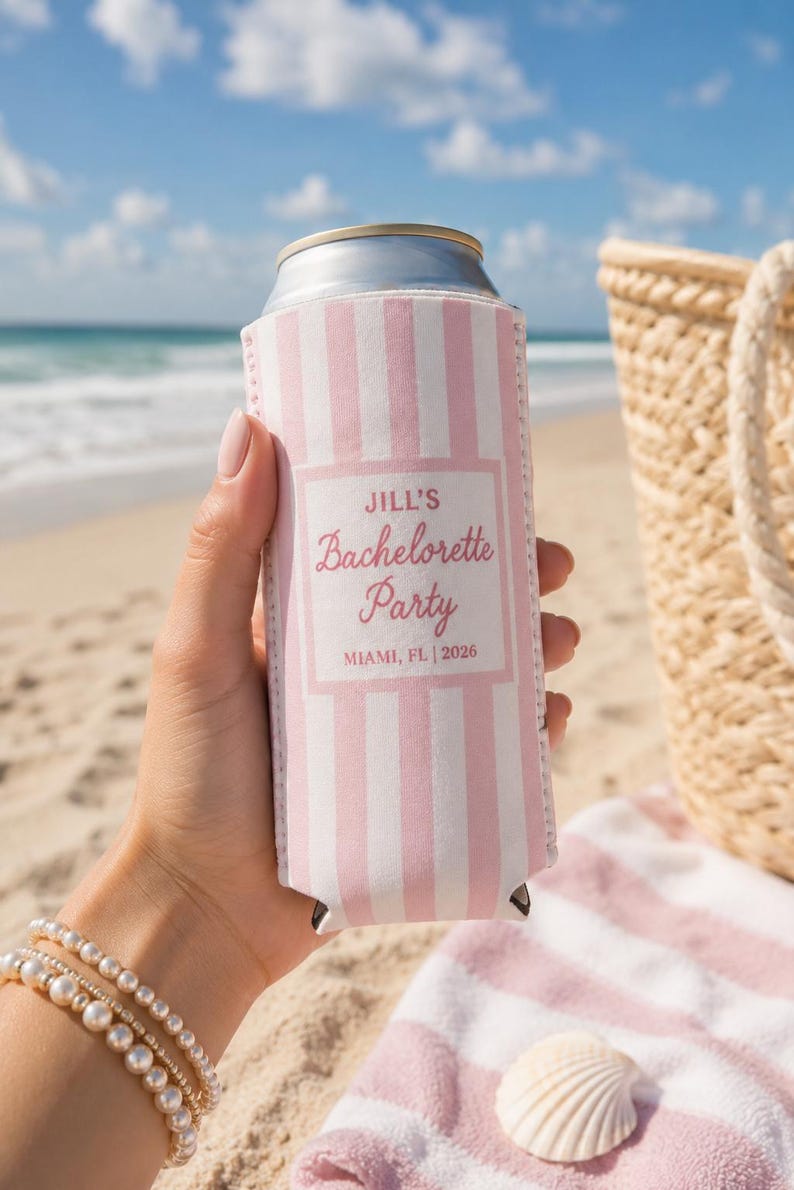 Peut inclure: Un refroidisseur de canette &agrave; rayures roses et blanches avec le texte "Jill's Bachelorette Party, Miami, FL | 2026". Le refroidisseur est tenu sur une plage avec un coquillage et une serviette ray&eacute;e en arri&egrave;re-plan.