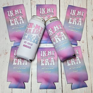 May include: Set of eight colorful can coolers with the text "In My Bachelorette Era" and a different name on each cooler. The coolers are pink, blue, and purple with a tie-dye pattern.