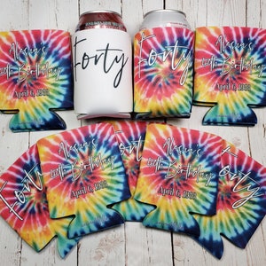 Puede incluir: Conjunto de 8 enfriadores de latas de tie-dye con el texto "Alessia's 40th Birthday" y "Forty" en blanco. Los enfriadores est&aacute;n en un patr&oacute;n de tie-dye arco&iacute;ris.