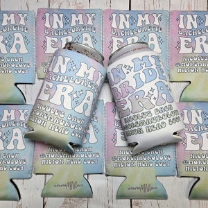 May include: A set of six colorful can coolers with the text "In My Era" and "In My Bride Era" in a retro font. The coolers are decorated with a tie-dye pattern and stars. The text "Nicole's Bach #MoreMauroLove Hilton Head 2024" is printed on each cooler.