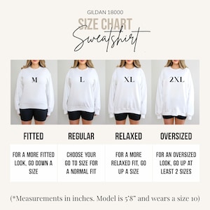 May include: White Gildan sweatshirt size chart with models wearing sizes M, L, XL, and 2XL. Text includes "Fitted", "Regular", "Relaxed", and "Oversized" with sizing recommendations. The model is 5'8" and wears a size 10.