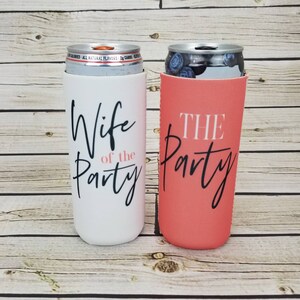 May include: Two white and coral can coolers with black text. The white cooler says "Wife of the Party" and the coral cooler says "The Party".