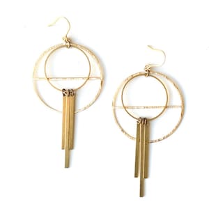 May include: Gold tone geometric earrings with a circle and a line design and dangling bars.