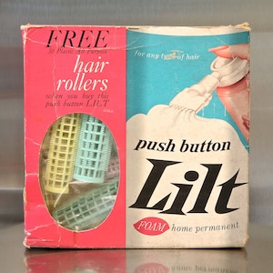 May include: A pink and blue box with the words 'FREE 36 Plastic All Purpose hair rollers' and 'push button Lilt FOAM home permanent' printed on it. The box includes a set of plastic hair rollers and a picture of a woman using a hair setting product.