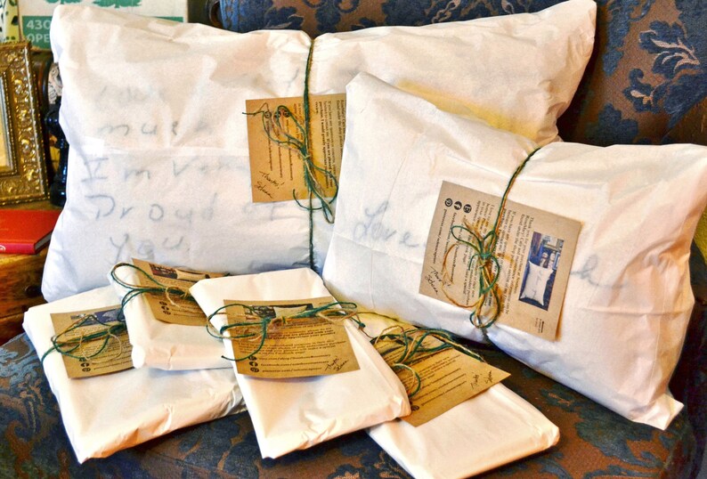 May include: Six white pillowcases wrapped in brown paper with green twine and a handwritten note on each. The notes say "Love", "I'm very proud of you", and "Must be a good girl".