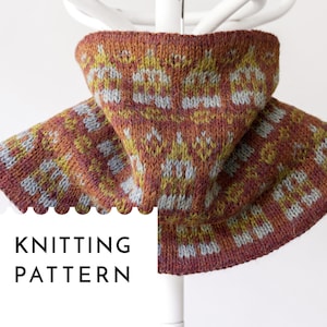May include: A knitted cowl in shades of rust, yellow, and blue, displayed on a white hanger. The cowl features a geometric pattern and the text "KNITTING PATTERN" in a black box.