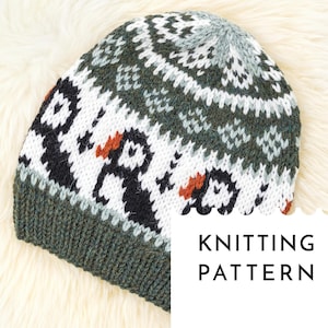 May include: A knitted beanie hat with a pattern of penguins in black, white, and orange. The hat has a dark green brim and a white, green, and gray patterned crown. The text "KNITTING PATTERN" is on a white rectangle.