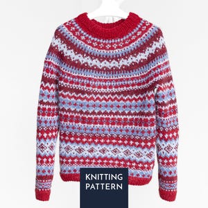 Op de afbeelding: Een gebreide trui met lange mouwen en een herhalend geometrisch patroon in rood, lichtblauw en wit. Het kledingstuk heeft een ronde halslijn en geribbelde boorden. Een donkerblauwe rechthoek onderaan toont de tekst KNITTING PATTERN.