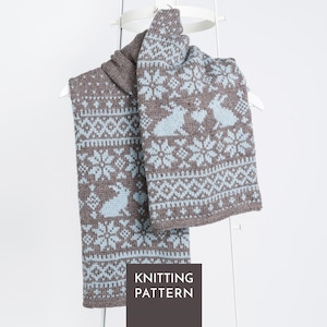 May include: A brown and light blue knit scarf featuring a repeating pattern of snowflakes, geometric shapes, and rabbits with a heart between them. A dark brown square overlay at the bottom contains the white text KNITTING PATTERN.