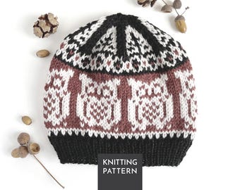 Könnte beinhalten: Eine gestrickte Mütze mit einem sich wiederholenden Eulenmotiv in Weiß auf altrosa Hintergrund. Die Mütze hat einen einfarbigen schwarzen Rippsaum und ein schwarz-weißes geometrisches Muster an der Krone. Der Text KNITTING PATTERN ist sichtbar.